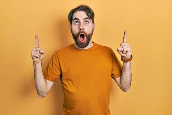 Hombre Caucásico Con Barba Vistiendo Casual Camiseta Amarilla Asombrado Sorprendido —  Fotos de Stock