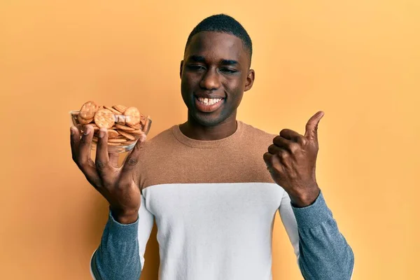 Young African American Man Holding Bowl Salty Biscuits Smiling Happy — Stock Photo, Image