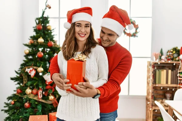 Jeune Couple Hispanique Portant Chapeau Noël Tenant Cadeau Maison — Photo