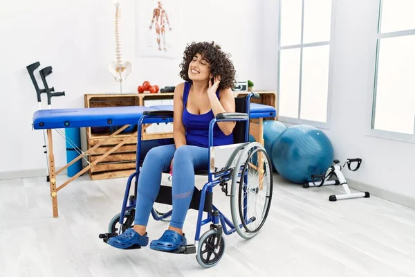 Fizyoterapi Kliniğinde Tekerlekli Sandalyede Oturan Genç Ortadoğulu Bir Kadın Kulağından — Stok fotoğraf