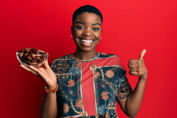 Joven Mujer Afroamericana Sosteniendo Tazón Con Fechas Sonriendo Feliz Positivo — Foto de Stock