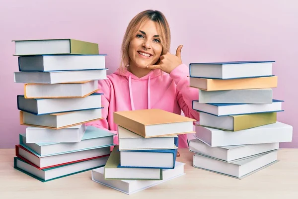 Mujer Caucásica Joven Sentada Mesa Con Libros Sonriendo Haciendo Gesto —  Fotos de Stock