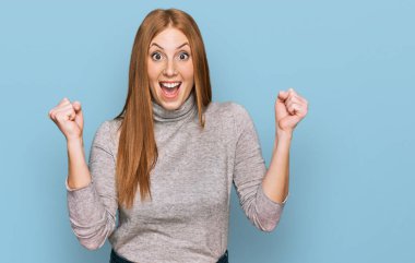 Sıradan kıyafetler giyen genç İrlandalı kadın şaşkınlık ve şaşkınlık içinde kollarını kaldırarak ve gözlerini açarak başarıyı kutluyor. Kazanan konsept. 