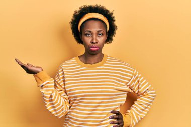 Genç Afro-Amerikalı kadın avuçlarını açmış, depresif ve endişeli bir şey tutuyor, kızgın ve korkmuş bir şekilde ağlıyor. hüzünlü ifade. 