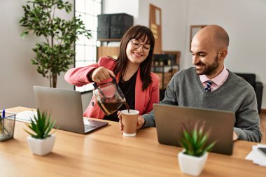İki İspanyol iş adamı mutlu gülümsüyor. Ortağım ofiste kahve dolduruyor..