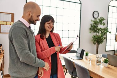 Ofiste çalışırken gülümseyen iki İspanyol iş adamı..