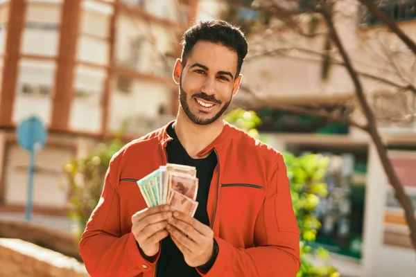 年轻的惊慌失措的男人高兴地微笑着 在城里拿着印度卢比钞票 — 图库照片