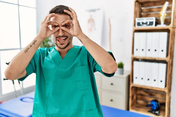 Young Physiotherapist Man Working Pain Recovery Clinic Doing Gesture Binoculars — Stock Photo, Image