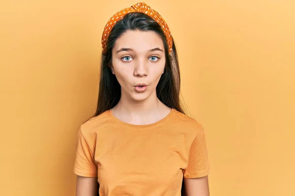 年轻的黑发女孩穿着随意的橙色T恤 吓得张大了嘴 满脸诧异 — 图库照片