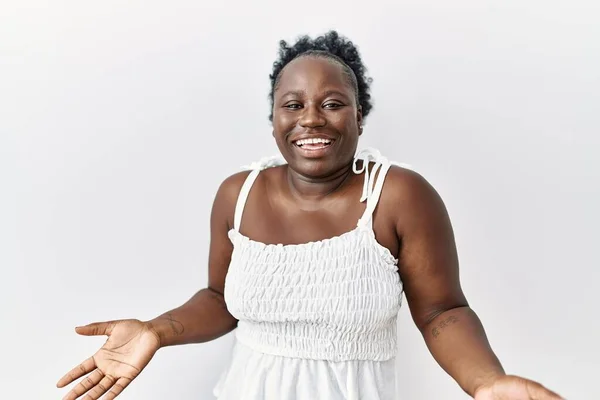 年轻的非洲女人站在白色孤立的背景上 高兴地微笑着 张开双臂表示友好的欢迎 积极和自信的问候 — 图库照片