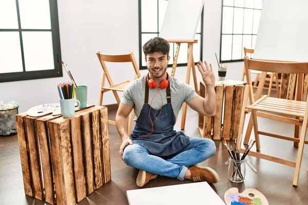 Jonge Spaanse Man Zit Kunststudio Tonen Wijzen Met Vingers Nummer — Stockfoto