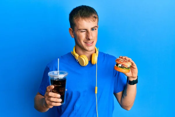 Giovane Uomo Caucasico Mangiare Gustoso Hamburger Classico Soda Ammiccante Guardando — Foto Stock