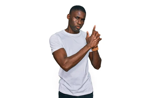 若いアフリカ系アメリカ人の男性は 手のジェスチャーで象徴的な銃を保持カジュアル白いTシャツを着て 銃を撃ち殺す演奏 怒りの顔 — ストック写真