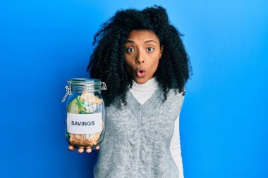 Afro saçlı Afrikalı bir kadın, elinde tasarruf kavanozuyla Güney Afrika 'dan para aşırıyor. Korkutuyor ve hayrete düşürüyor. 