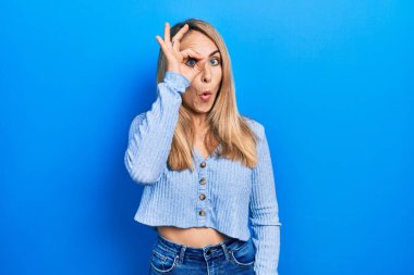 Kafkasyalı genç bir kadın günlük kıyafetler giyiyor. Şaşırmış bir yüz ve parmaklarından bakan bir gözle iyi bir hareket yapıyor. İnançsız ifade. 