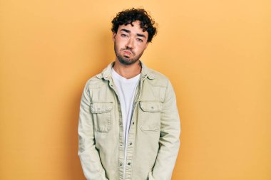 Günlük kıyafetler giyen genç İspanyol adam komik yüzlü yanakları şişiriyor. Havayla şişmiş ağız, çılgın bir ifade.. 