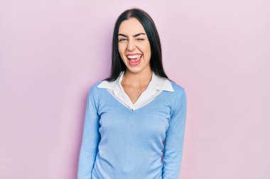 Pembe arka planda duran mavi gözlü güzel kadın kameraya seksi bir ifadeyle bakıyor, neşeli ve mutlu bir yüzle.. 