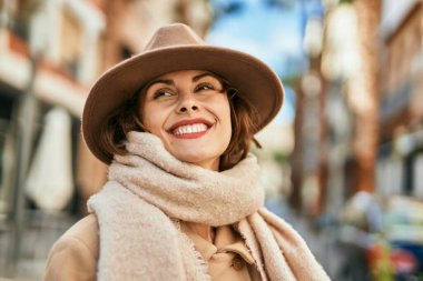 Şık giyinen genç İspanyol kadın şehirde dikiliyor..