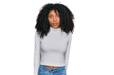 Sıradan kıyafetler giyen genç Afro-Amerikalı kız yüzünde ciddi bir ifadeyle rahatladı. Basit ve doğal bir şekilde kameraya bakıyorsun.. 