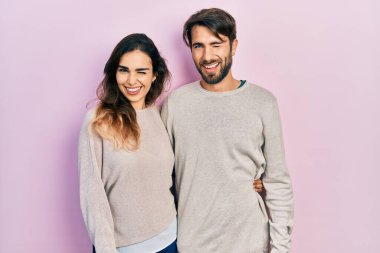 Gündelik kıyafetler giyen genç İspanyol çift kameraya seksi bir ifadeyle bakıyor, neşeli ve mutlu bir yüzle.. 