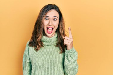 Gündelik kıyafetler giyen genç İspanyol kız başarılı bir fikri işaret ediyor. Heyecanlı ve mutlu. Bir numara.. 