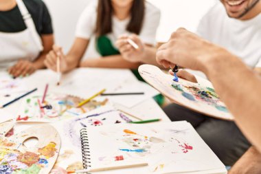 Resim stüdyosunda çizim yapan bir grup insan..