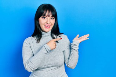 Gündelik kıyafetler giyen genç İspanyol kadın kameraya hayret ediyor ve gülümsüyor.. 