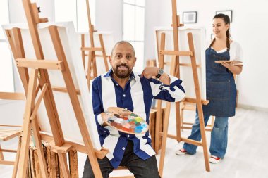 Sanat stüdyosundaki kıdemli sanatçı, kendine güveni tam görünüyor, kendini gururlu ve mutlu bir şekilde gösteriyor.. 