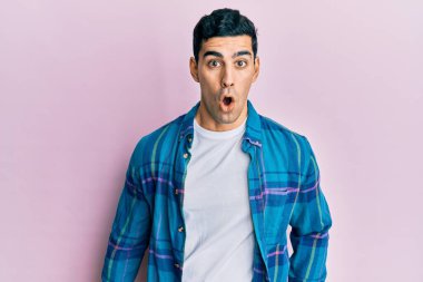 Yakışıklı İspanyol bir adam, günlük kıyafetler giyiyor. Şaşırmış ve korkmuş bir ifade, korku ve heyecanlı bir yüz ifadesi var.. 