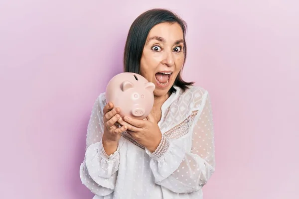 Medelåldern Hispanic Kvinna Håller Spargris Bank Firar Galen Och Förvånad — Stockfoto