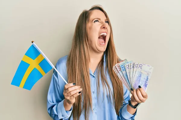 Elinde Sveç Bayrağı Krone Banknotları Tutan Genç Sarışın Kadın Kızgın — Stok fotoğraf