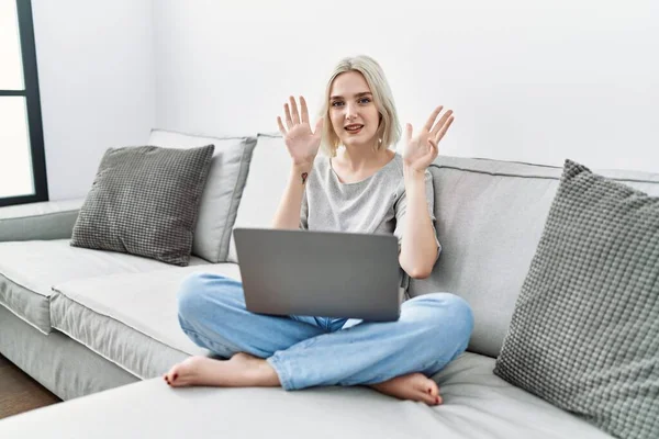 Młoda Kaukaska Kobieta Pomocą Laptopa Domu Siedzi Kanapie Pokazując Wskazując — Zdjęcie stockowe