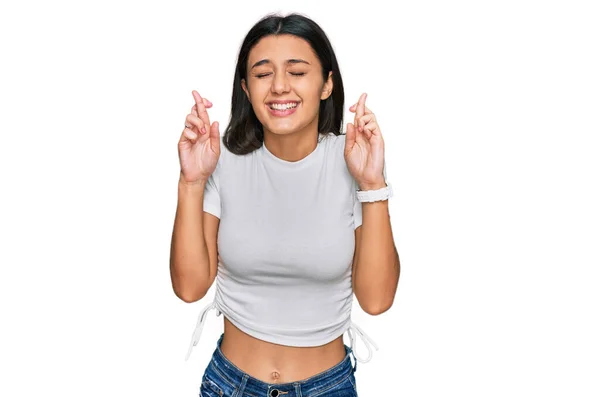 Menina Hispânica Jovem Vestindo Casual Branco Shirt Gesto Dedo Cruzado — Fotografia de Stock