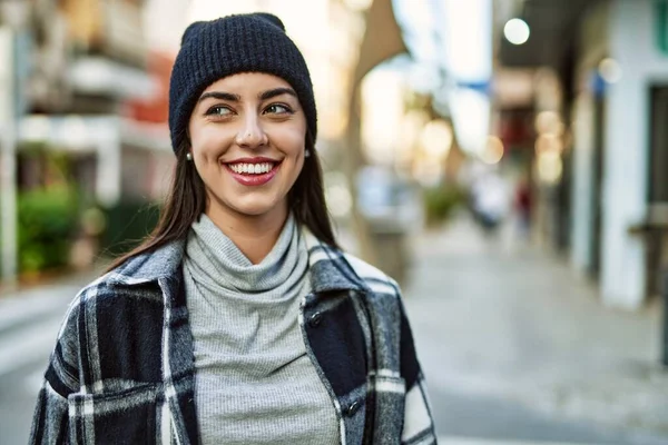 Genç İspanyol kadın gülümseyerek şehirde mutlu mesut dikiliyor..