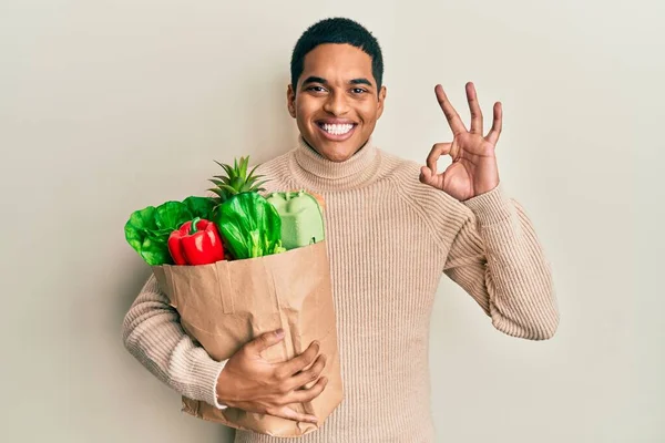 Joven Hombre Hispano Guapo Sosteniendo Bolsa Papel Con Comestibles Haciendo —  Fotos de Stock