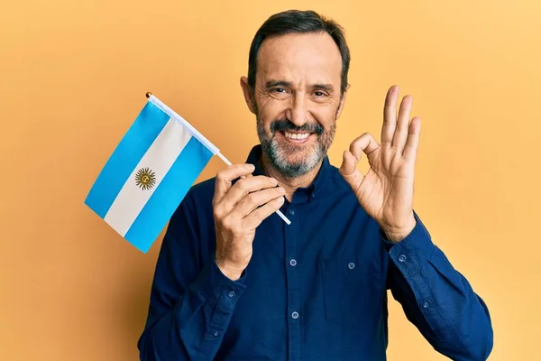 Medelålders Latinamerikan Man Håller Argentina Flagga Gör Tecken Med Fingrar — Stockfoto