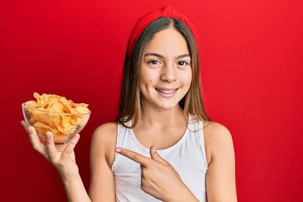 Hermosa Niña Morena Sosteniendo Papas Fritas Sonriendo Feliz Señalando Con — Foto de Stock