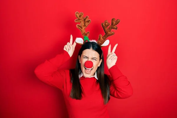 Jovem Hispânica Usando Chapéu Natal Veado Nariz Vermelho Posando Engraçado — Fotografia de Stock