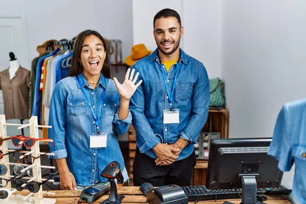 在零售精品店工作的不同种族的年轻人带着自信和快乐的微笑 展示并指点着5号手指 — 图库照片