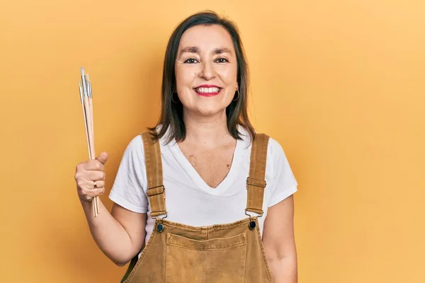 Mulher Hispânica Meia Idade Segurando Pincéis Olhando Positivo Feliz Sorrindo — Fotografia de Stock