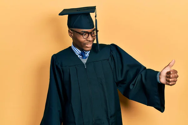 Νεαρός Αφροαμερικάνος Που Φοράει Καπέλο Αποφοίτησης Και Επίσημη Ρόμπα Δείχνοντας — Φωτογραφία Αρχείου