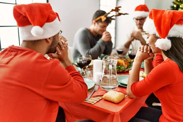 クリスマスを祝う若者のグループ自宅でテーブルの上に座って食べ物を祈る — ストック写真