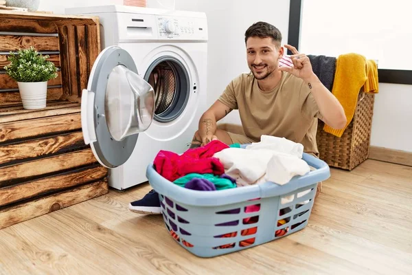 Joven Hombre Guapo Poniendo Ropa Sucia Lavadora Sonriente Seguro Gesto —  Fotos de Stock