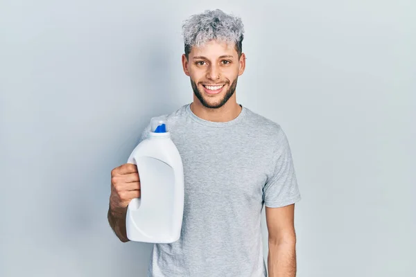 Homem Hispânico Jovem Com Moderno Cabelo Tingido Segurando Garrafa Detergente — Fotografia de Stock