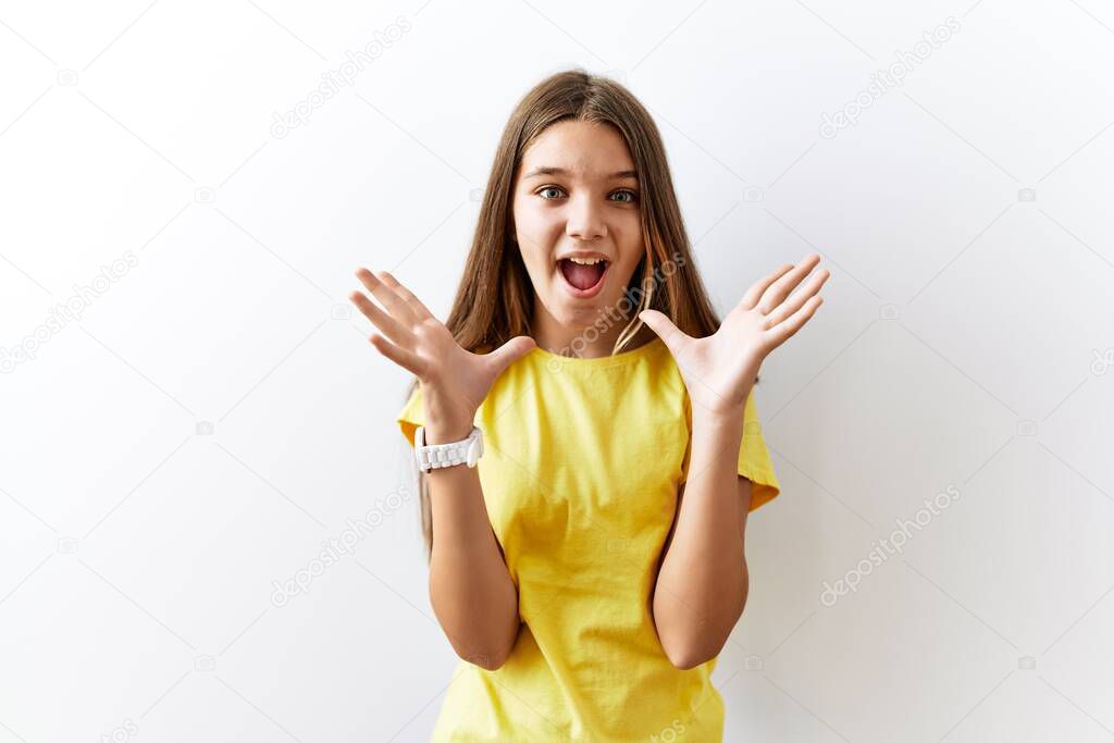 Young brunette teenager standing together over isolated background celebrating crazy and amazed for success with arms raised and open eyes screaming excited. winner concept 