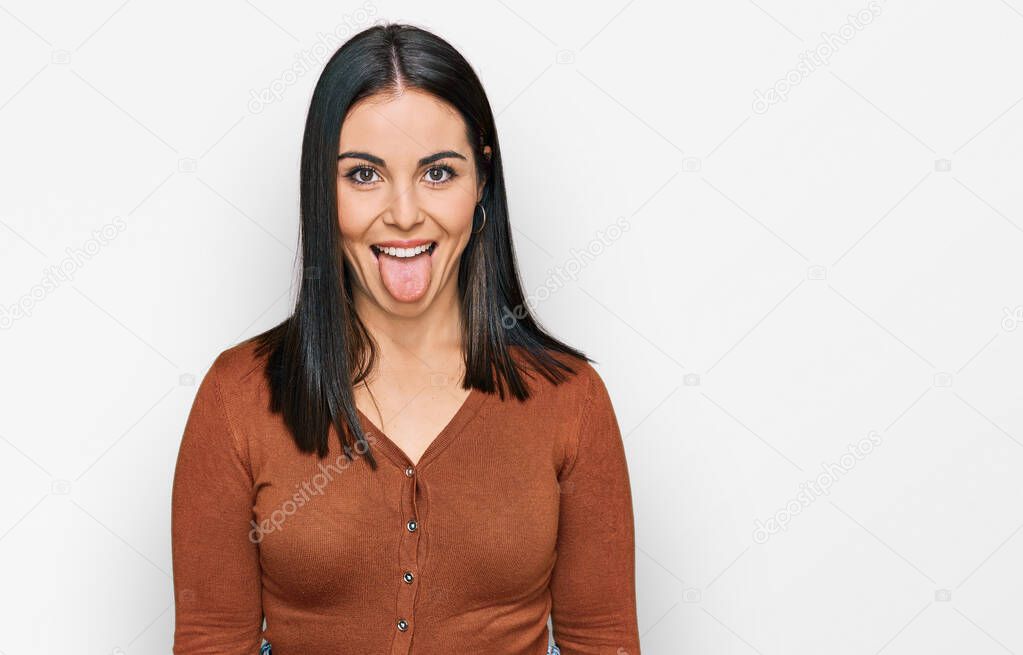 Young hispanic woman wearing casual clothes sticking tongue out happy with funny expression. emotion concept. 