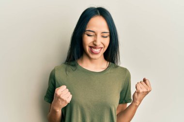 Kolları havada ve gözleri kapalı zaferi kutlayan sıradan bir tişört giyen İspanyol genç kız. Kazanan konsept. 