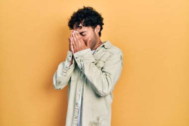 Ağlarken suratını ellerle kapatan, günlük kıyafetler giyen genç İspanyol. depresyon kavramı. 