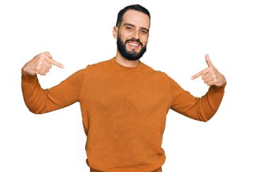 Sakallı genç adam, sıradan bir kazak giyiyor. Kendine güvenen, gülümseyen, kendini gururlu ve mutlu gösteren biri.. 