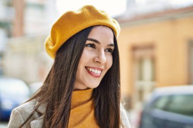 Genç İspanyol kız gülümseyerek şehirde mutlu mesut dikiliyor..